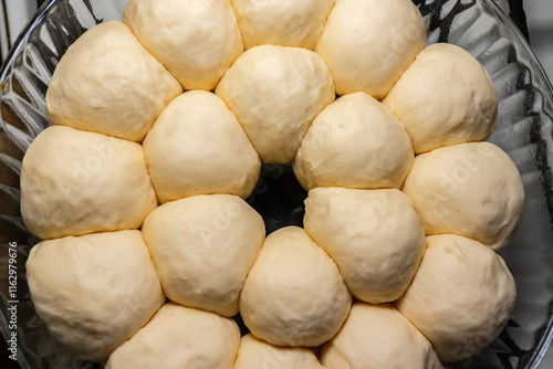 Buns from raw dough are ready to be baked in the oven. Cooking classic homemade dinner rolls close-up photo