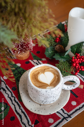 Obraz na płótnie Close up of Hot coffee latte with latte art milk foam in cup mug with Xmas decors and Xmas tree baubles on wood desk Celebrating Merry Christmas and New year,Merry x-mas w salonie