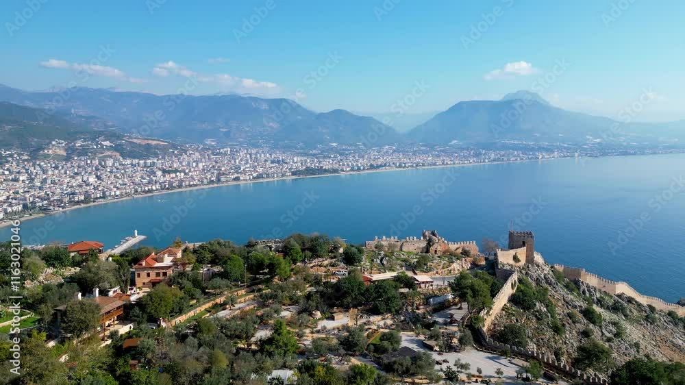 Aerial drone shot of Alanya city and blue ocean in Turkey showing the lighthouse, Red tower, and Alanya Castle. Aerial drone shot of Alanya city and blue ocean in Turkey showing the lighthouse, Red tower, and Alanya Castle.