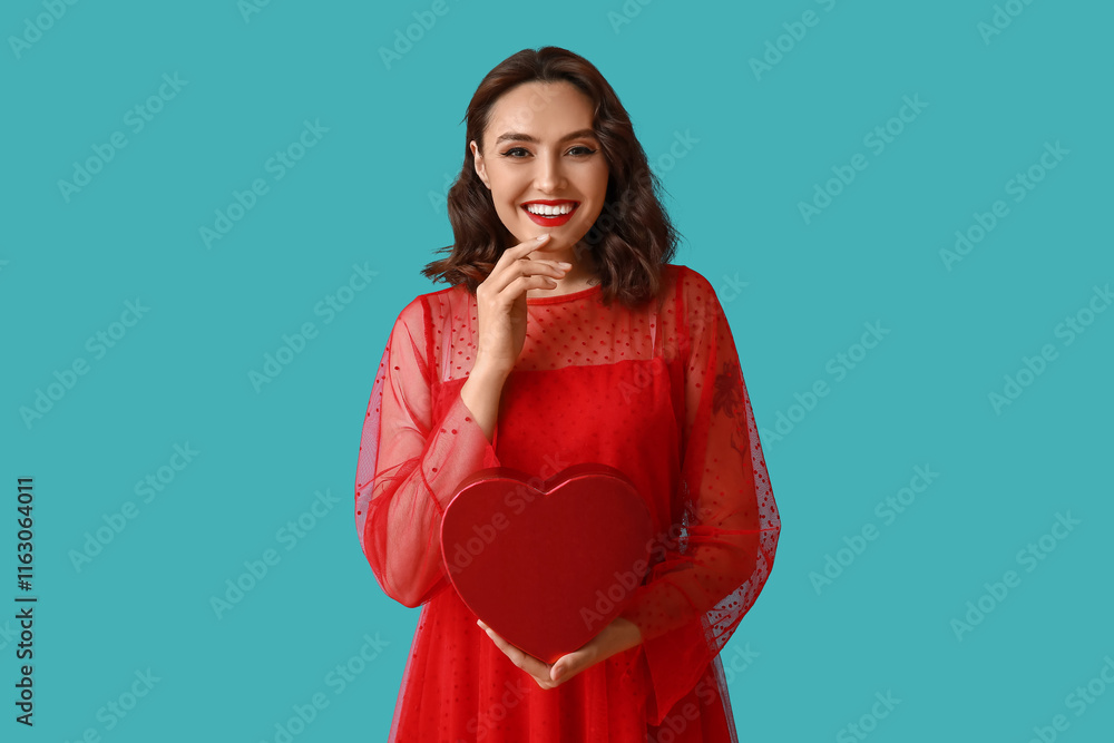 Beautiful young woman with heart shaped gift box on blue background Beautiful young woman with heart shaped gift box on blue background