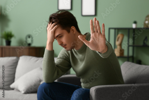 Depressed young man sitting...