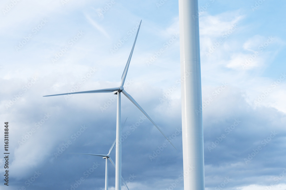 Tall wind turbine harnessing wind power with blue sky in the background in rural Estonia, Northern Europe Tall wind turbine harnessing wind power with blue sky in the background in rural Estonia, Northern Europe