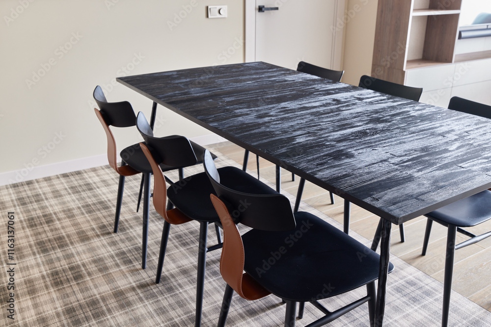 A Modern Dining Table Accompanied by Stylish Black Chairs in a Contemporary Interior Space A Modern Dining Table Accompanied by Stylish Black Chairs in a Contemporary Interior Space