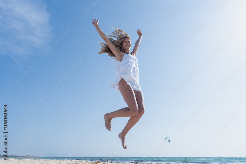 Mujer joven saltando de emoción porque esta feliz y divertida, con un sensacional día de vacaciones en verano en la playa, soleado con cielo azul. Mujer joven saltando de emoción porque esta feliz y divertida, con un sensacional día de vacaciones en verano en la playa, soleado con cielo azul.