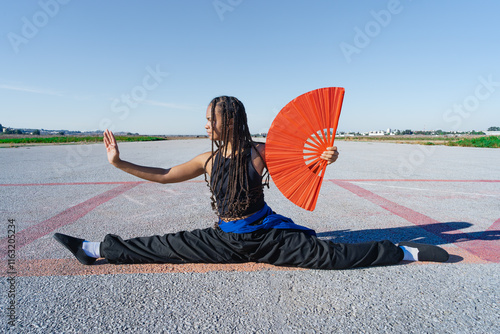 bailarina de danza oriental realiza figuras bonitas y elegantes, con el fondo infinito y minimalista de una pista de aterrizaje y espacio para texto, un día soleado con cielo azul. photo