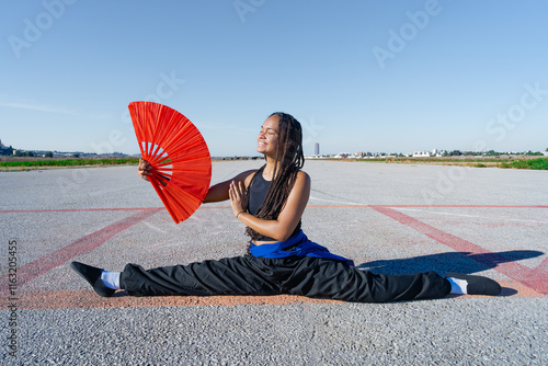 bailarina de danza oriental realiza figuras bonitas y elegantes, con el fondo infinito y minimalista de una pista de aterrizaje y espacio para texto, un día soleado con cielo azul. photo