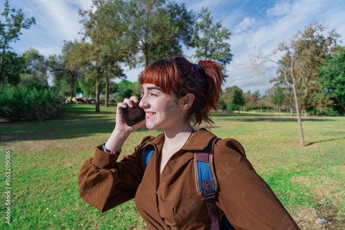 Chica joven atravesando un parque de camino al trabajo, instituto o universidad, un día soleado de verano. photo