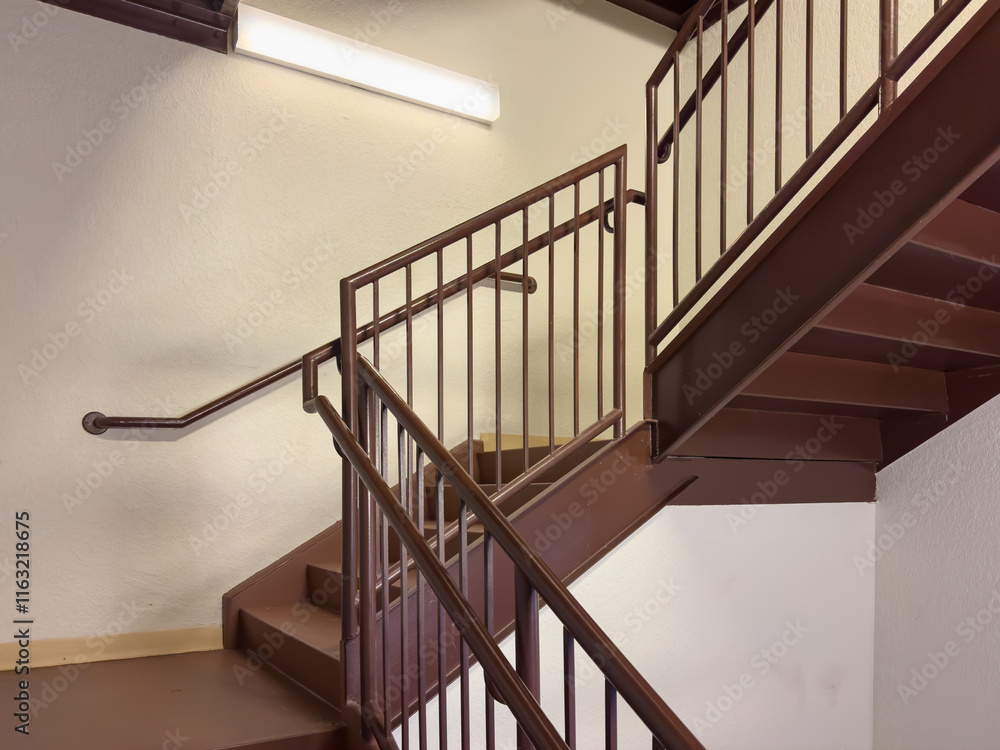 Close-up photo of a brown metal exit stairway, stair case, between floors of a commercial building. Close-up photo of a brown metal exit stairway, stair case, between floors of a commercial building.