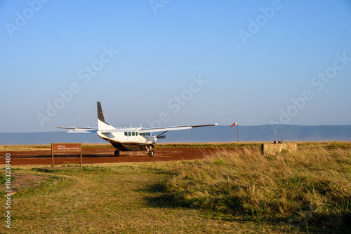 Airplane on the dirt airstrip at the Mara Serena Air Strip in the Maasai Mara National Reserve, African wildlife adventure safari in Kenya
