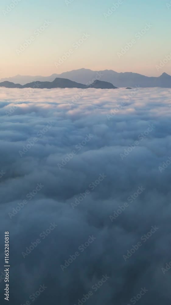Vertical Drone fly above white clouds, sky covered, white cloudscape, mountain sunset background at Tropical Area Vertical Drone fly above white clouds, sky covered, white cloudscape, mountain sunset background at Tropical Area