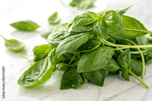 A handful of fresh basil leaves on a white surface