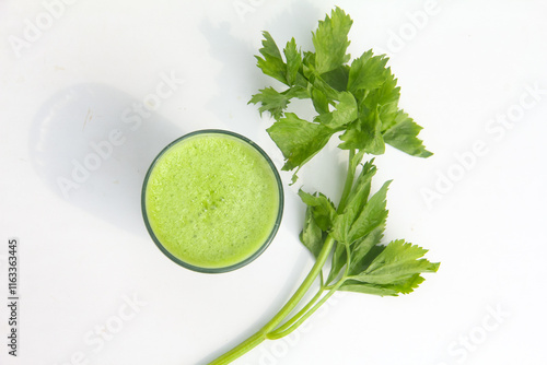 Celery juice, healthy green drink made from celery, green celery smoothie decorated with fresh green celery leaves