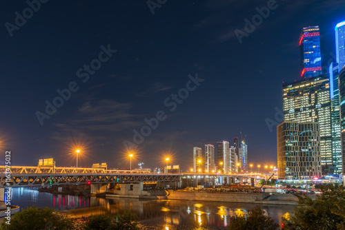 The scyscrapers of the Moscow City at night and the Dorogomilovsky bridge with illumination. Translation of text - street names: Krasnopresnenskaya, center, etc. photo