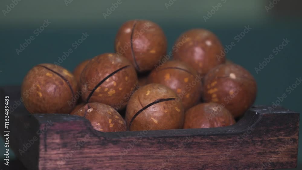 Close up of macadamia nuts in wooden bowl showcasing gourmet quality and texture in natural light Close up of macadamia nuts in wooden bowl showcasing gourmet quality and texture in natural light