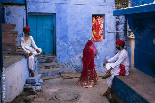 Woman walking and two indian men in traditional costume  and turban in the blue city , Jodhpur, India photo