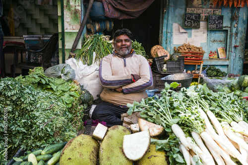 Indian man at the market stall selling vegetables in the old city, Delhi, India photo