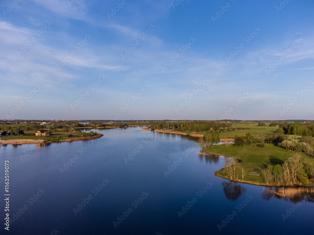 A serene island surrounded by calm blue water. Aerial view of a peaceful green island, tranquil mood, high-angle shot, rural countryside setting, concept of nature, and relaxation. A serene island surrounded by calm blue water. Aerial view of a peaceful green island, tranquil mood, high-angle shot, rural countryside setting, concept of nature, and relaxation.
