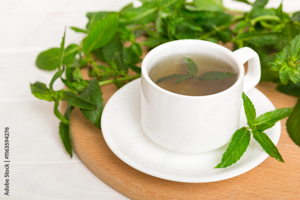 Cup of mint tea on table background. Green tea with fresh mint top view with copy space Cup of mint tea on table background. Green tea with fresh mint top view with copy space