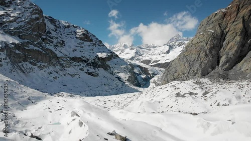 Aerial view of Gorner glacier in Zermatt, Switzerland covered in snow on a sunny winter day in the Swiss Alps with a view of Ober Gabelhorn and glacial morraines. photo