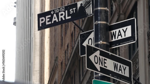 New York City, United States. Lower Manhattan Downtown Financial District. Pearl street corner road sign near Wall street Stock Exchange building, USA Stock Market. One way traffic sign, oneway arrow. photo