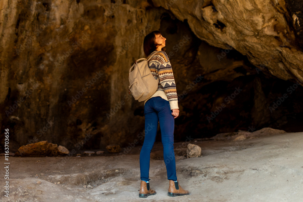 A young traveler with a backpack explores the caves. excursion to the cave. girl travels with a backpack. A young traveler with a backpack explores the caves. excursion to the cave. girl travels with a backpack.