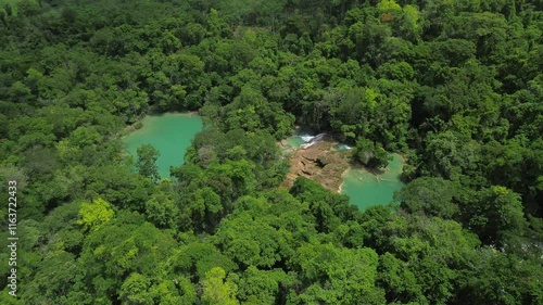 Aerial establishing pan left of Cascadas Roberto Barrios showcasing turquoise waterfalls in lush forest photo