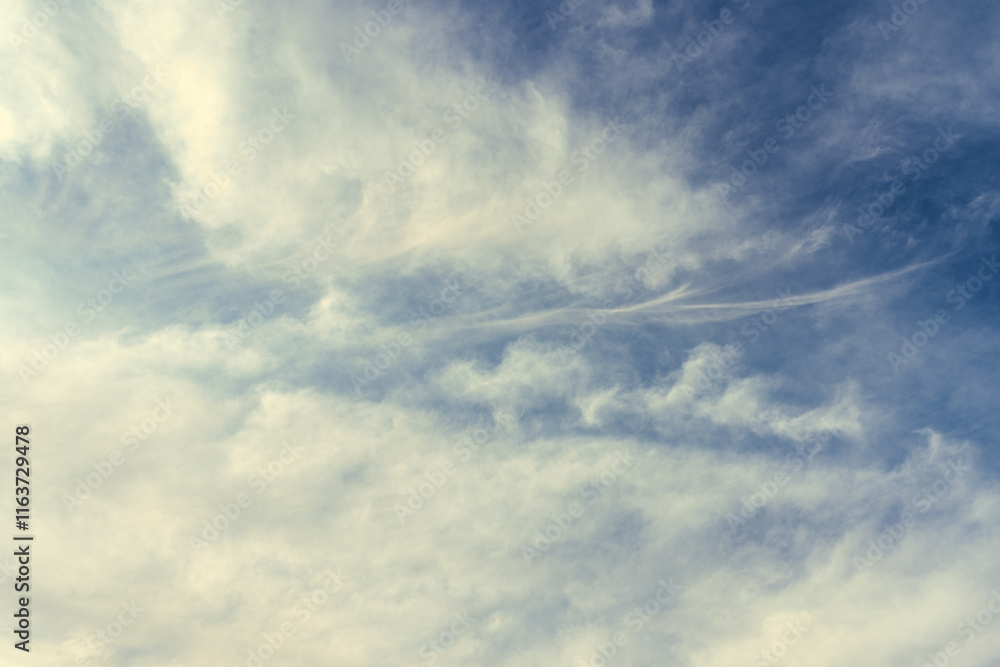 Milk-yellow clouds flutter in the wind, covering the blue sky with their veil. Natural phenomena created in the atmosphere by sunlight in the daytime, landscape backgrounds Milk-yellow clouds flutter in the wind, covering the blue sky with their veil. Natural phenomena created in the atmosphere by sunlight in the daytime, landscape backgrounds