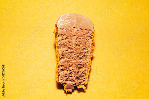 Chocolate ice cream bar reveals its smooth and creamy texture, encased by a crunchy waffle cone crust. Delightful treat offers a perfect contrast between rich chocolate ice cream and crisp waffle cone photo