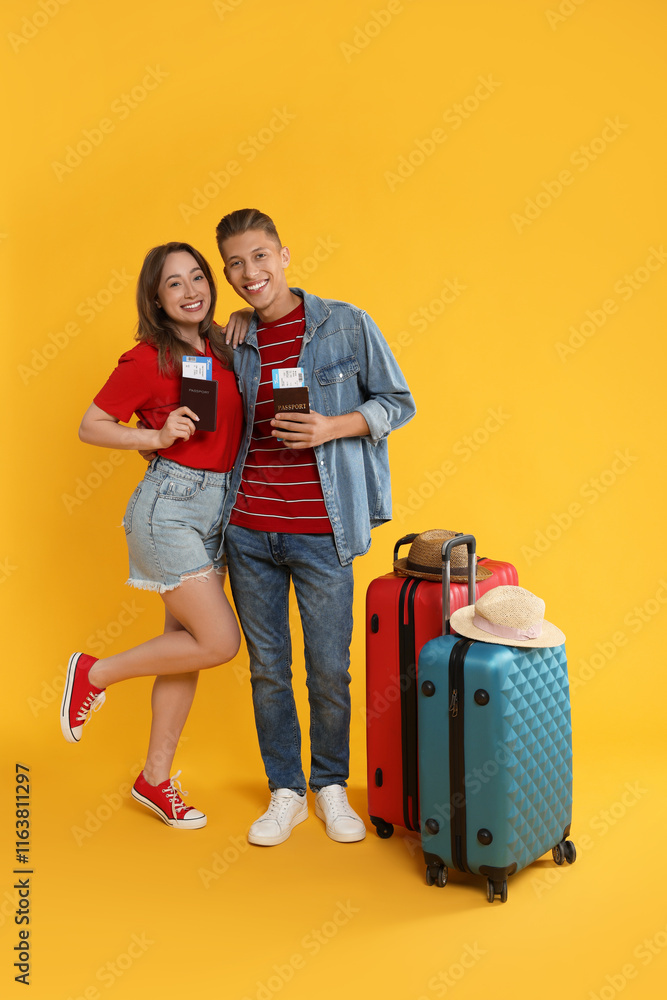 Happy travellers with passports, tickets and suitcases on yellow background Happy travellers with passports, tickets and suitcases on yellow background