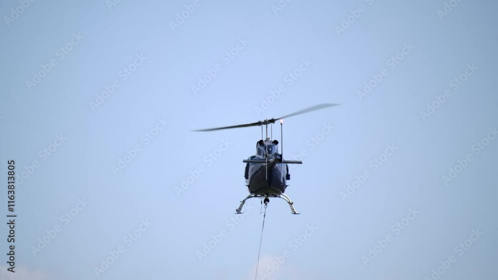 Rear View of Helicopter in Flight with Cable Attached to Belly SLOMO Rear View of Helicopter in Flight with Cable Attached to Belly SLOMO