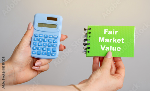 Fair Market Value concept. Price an asset would sell for on the open market when certain conditions are met. Business and finance. Calculator and notebook in hands photo