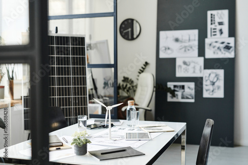 Wind turbine model with tablet PC kept on table in office photo