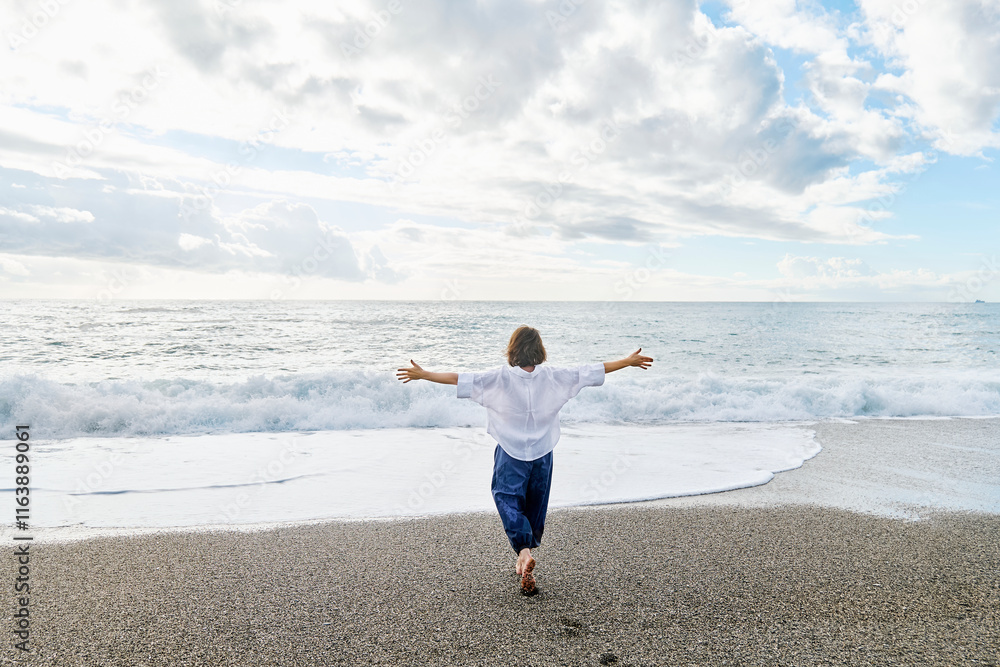 Carefree woman with arms outstretched walking at beach Carefree woman with arms outstretched walking at beach
