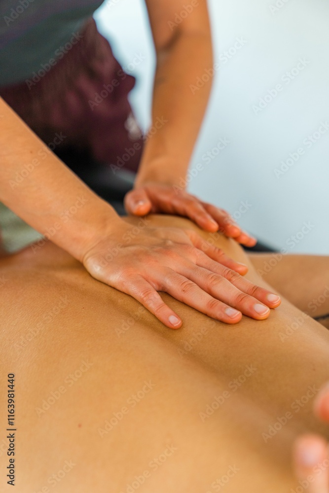 Massage therapist's hands on client's back. Massage therapist's hands on client's back.