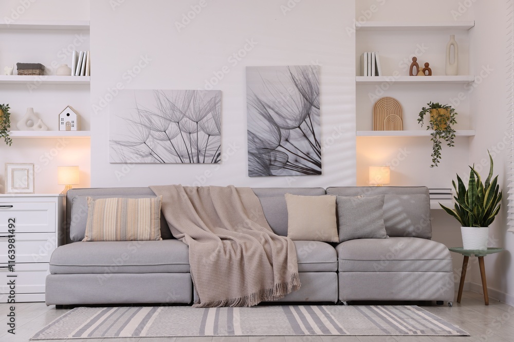 Comfortable sofa, houseplants and decorative elements in living room. Interior design Comfortable sofa, houseplants and decorative elements in living room. Interior design
