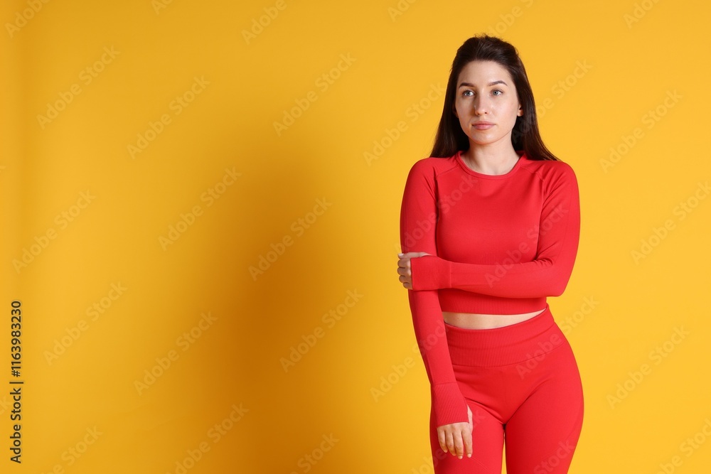 Obraz premium Portrait of woman in sportswear on orange background, space for text