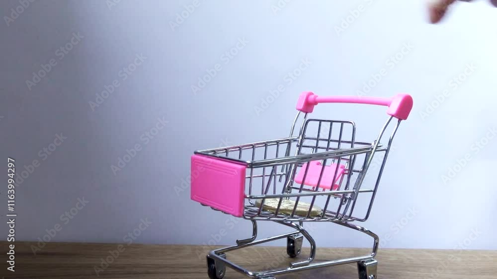 hand drops coin bitcoin into the shopping trolley hand drops coin bitcoin into the shopping trolley