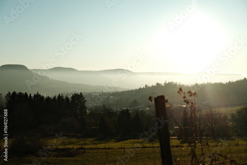 misty sunset over city with mountains