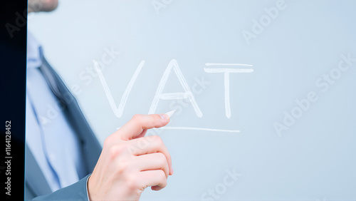 A businessman writing a VAT concept with a white pen on a clear screen.