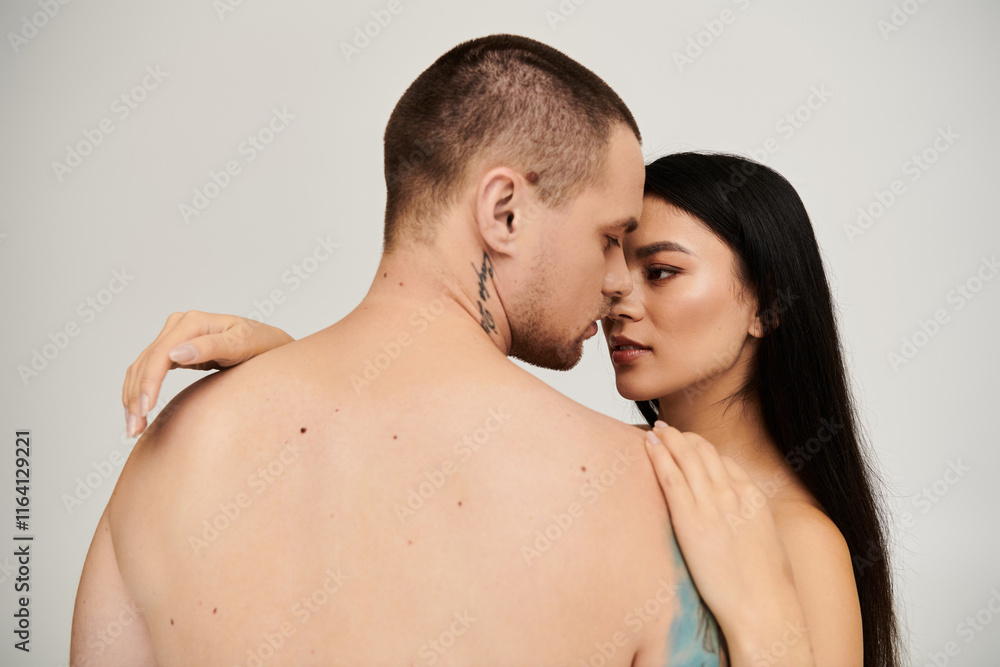 A seductive young couple shares an intimate moment in a studio, embodying romance and passion. A seductive young couple shares an intimate moment in a studio, embodying romance and passion.