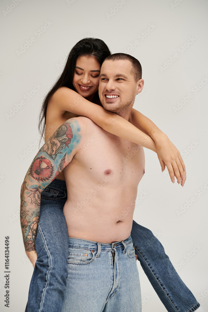 Seductive young couple embraces in a playful moment during a romantic studio shoot. Seductive young couple embraces in a playful moment during a romantic studio shoot.
