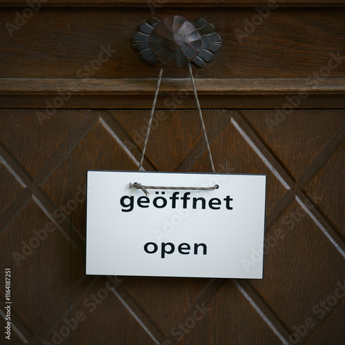 Schild an einer Eingangstür mit dem Wort offen, open in deutscher und englischer Sprache photo