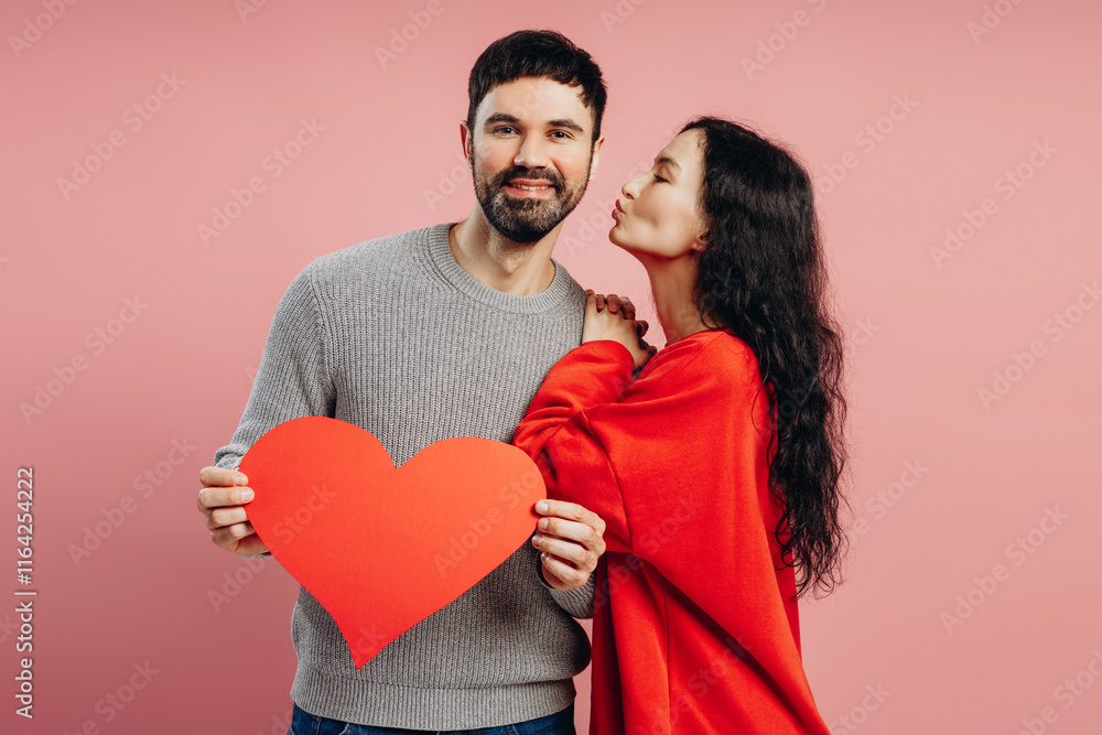 Couple holding big red heart and kissing on valentine's day Couple holding big red heart and kissing on valentine's day