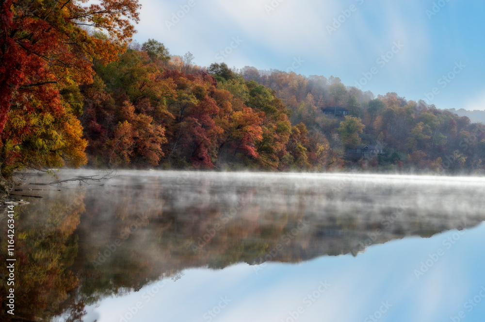 A serene lake reflects vibrant autumn foliage A serene lake reflects vibrant autumn foliage