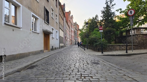 Bild auf Leinwand Metal fences line the edges of the cobbled city street with sidewalks