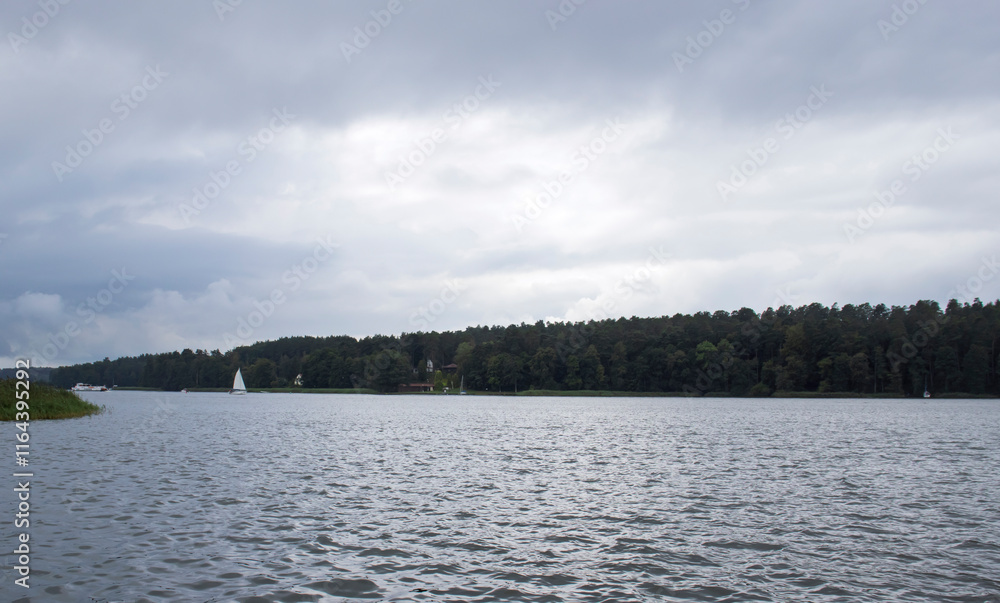 A serene landscape featuring a calm lake surrounded by dense forests under a cloudy sky, creating a peaceful atmosphere for outdoor activities and nature enthusiasts. A serene landscape featuring a calm lake surrounded by dense forests under a cloudy sky, creating a peaceful atmosphere for outdoor activities and nature enthusiasts.