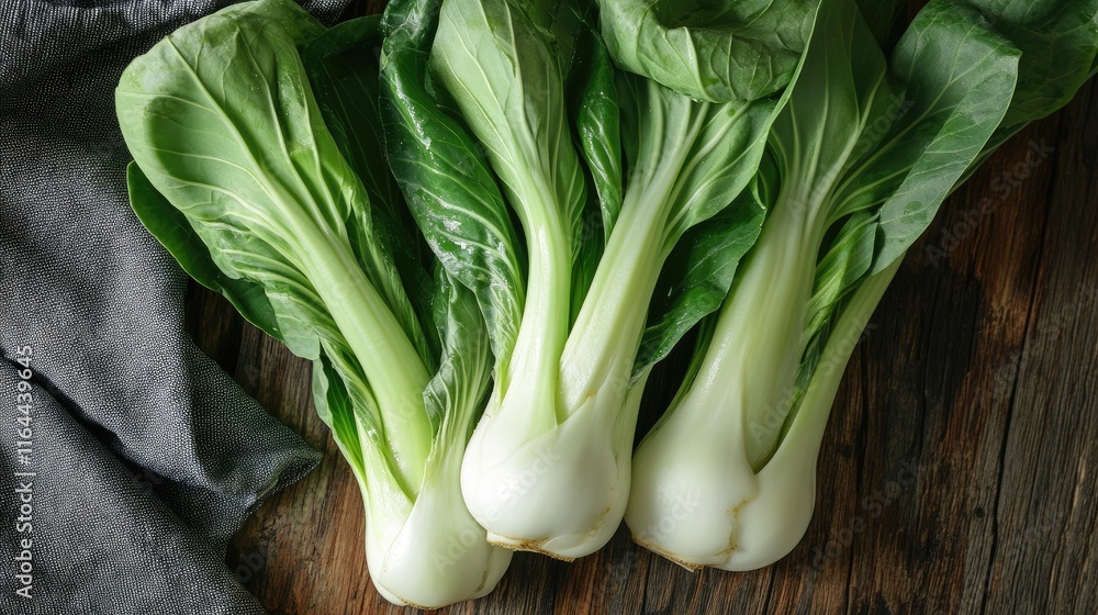 Fresh bok choy stalks on a wooden surface showcasing vibrant green leaves and healthy organic produce for culinary recipes Fresh bok choy stalks on a wooden surface showcasing vibrant green leaves and healthy organic produce for culinary recipes