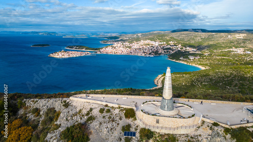 The Statue of Our Lady of Loreto near Primošten, Croatia, stands majestically on a hill overlooking the Adriatic Sea. Captured from a drone, this aerial view highlights the statue's serene presence photo