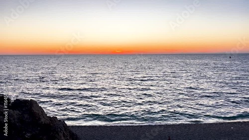 Beautiful tilting up shot of the Ocean Sunset with Waves Gently Washing Ashore during golden hour