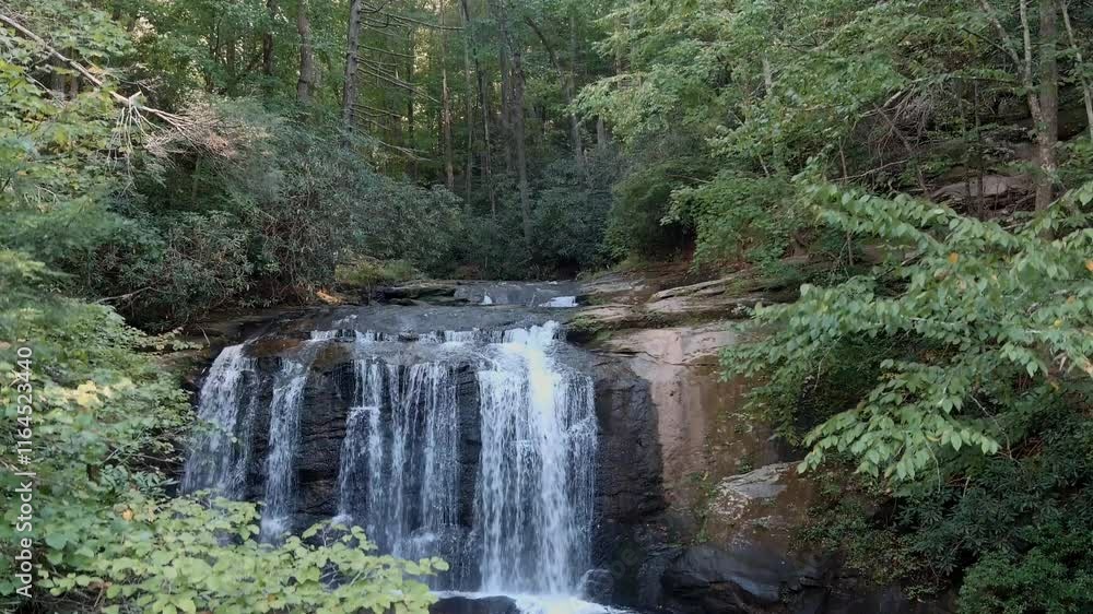 Descending drone shot of Little Bradley Falls, a waterfall in the mountains of North Carolina, USA. Descending drone shot of Little Bradley Falls, a waterfall in the mountains of North Carolina, USA.